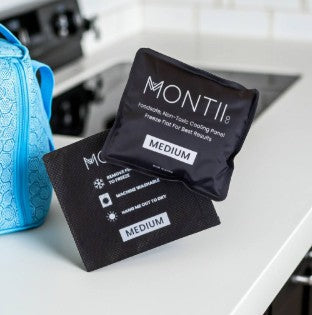A pair of MontiiCo medium cooling panels rest side by side on a clean countertop, ready for use in a child’s lunch bag.