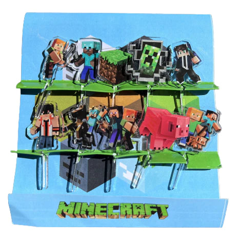 A set of acrylic food picks designed with characters from the Minecraft video game series, including figures like Steve and a pig. The picks are colored in various shades reflecting the game's aesthetic, and are attached to a blue background.