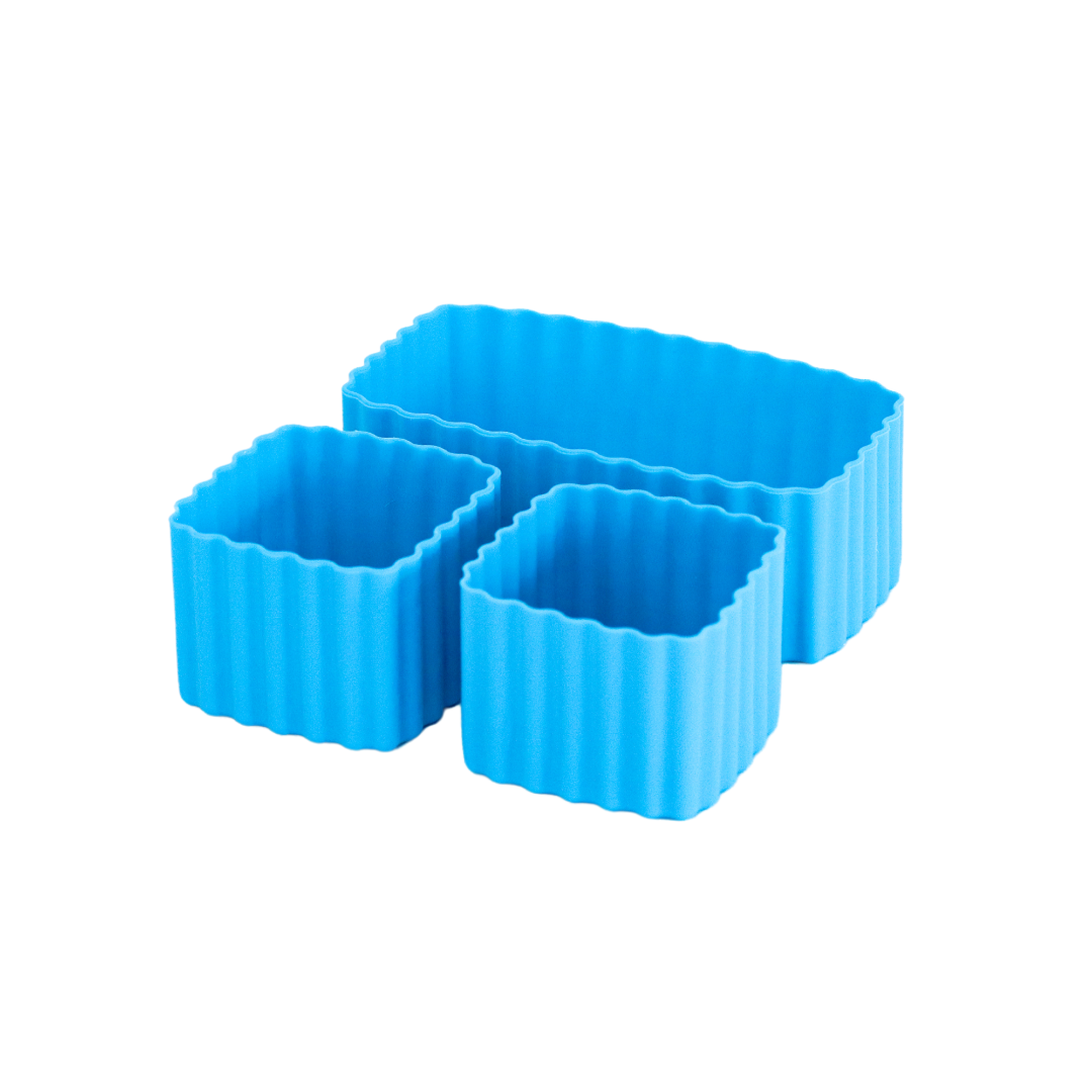 Set of coastal blue MontiiCo mixed bento cups with fluted sides, shown in multiple sizes for organising snacks in lunch boxes."