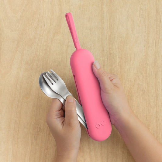 Pink OmieBox Up cutlery pod held in hand showing compact bento cutlery design.