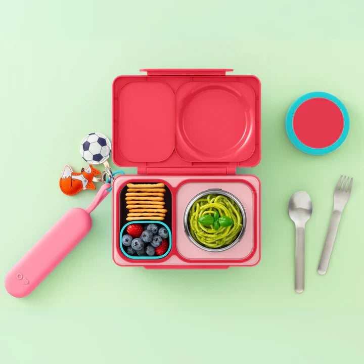 Pink OmieBox Up stainless steel cutlery set displayed beside matching lunch box