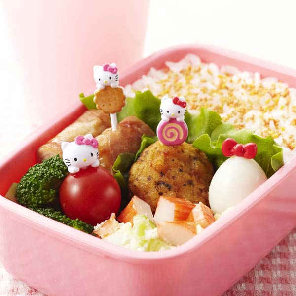 A pink bento box filled with rice, vegetables, boiled egg, croquette and crab sticks, decorated with cute Hello Kitty food picks for a fun kids lunch.