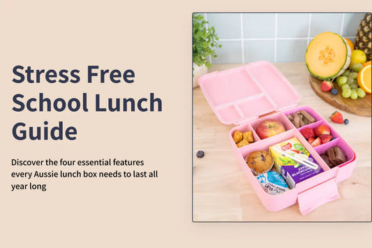 showing a school lunch guide banner with a pink compartment lunch box filled with fruit and snacks on a wooden surface, alongside bananas and a halved pumpkin.