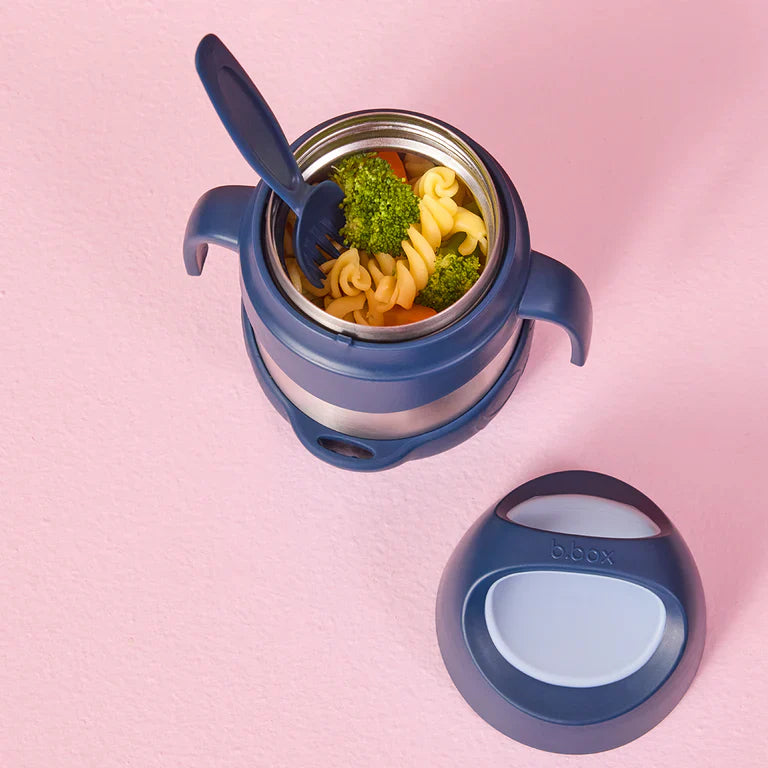 Blue thermos container with pasta and broccoli on a pink background