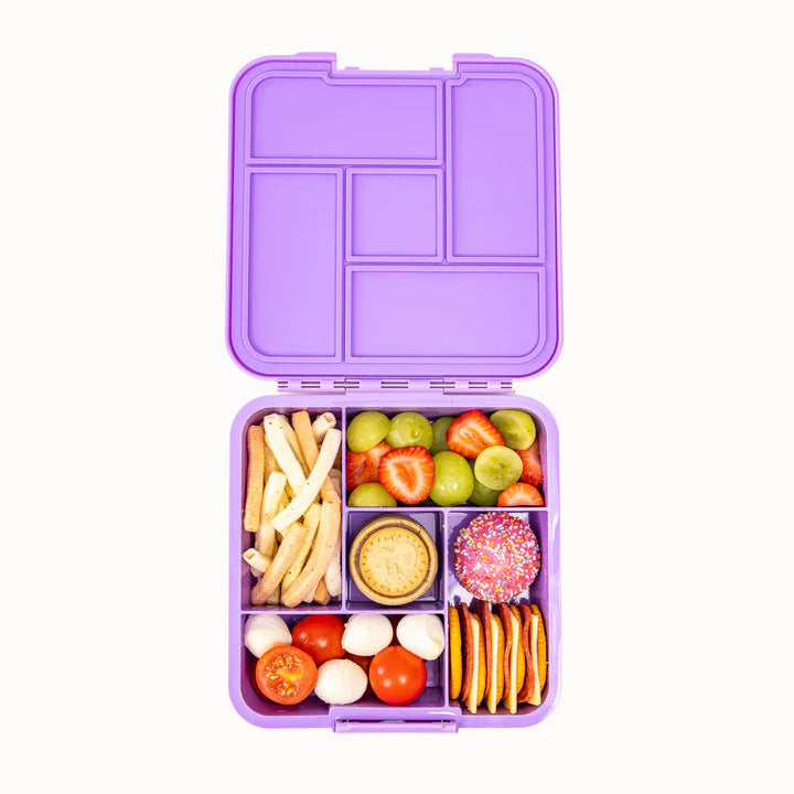 Top-down view of the purple MontiiCo Bento 5 lunch box packed with a variety of fresh snacks, fruit, and crackers across all five compartments.