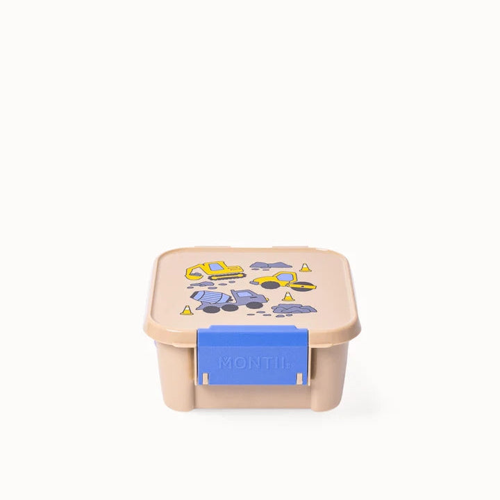 Front-facing angle of the closed beige MontiiCo Bento 2 snack box showing the bright blue latch.