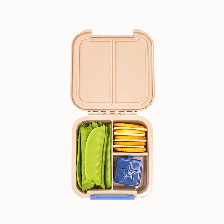 Top view of the open beige MontiiCo Bento 2 snack box packed with celery sticks, crackers, and snacks