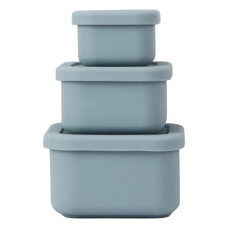 Three apollo blue silicone nesting containers of different sizes with lids, stacked together.