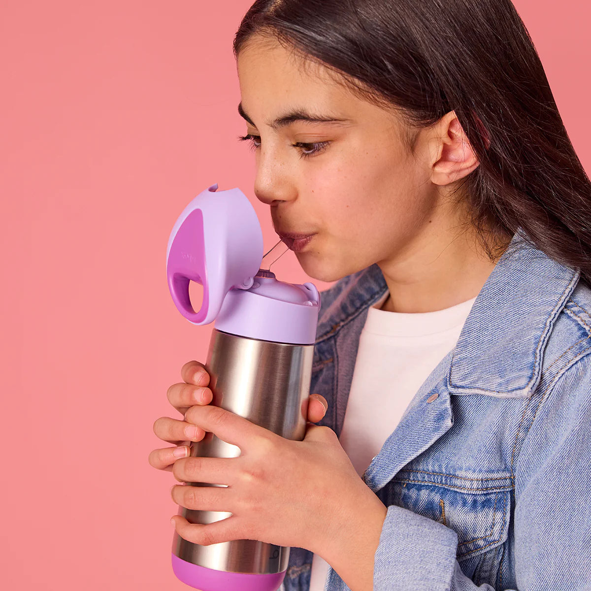 Person holding a  a sugar plum drink bottle from bbox  that pink and silver insulated drink container against a pink background