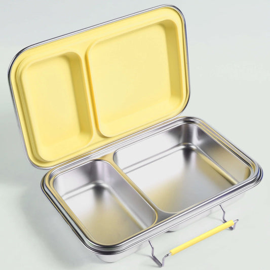 An open Ecococoon stainless steel leakproof bento box with two compartments, the larger compartment contains a sandwich, and the smaller one is empty. The box is placed on a white surface with a yellow lid on top and a yellow strap attached to it.