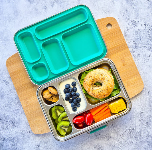 Bento box with compartments filled with a variety of food items on a wooden board.