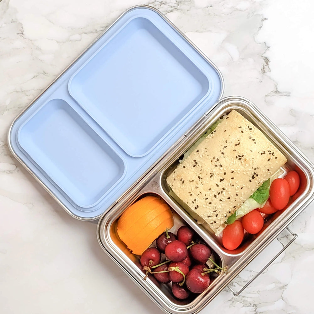 Ecococoon stainless steel leakproof bento box with two compartments and blueberry‑blue lid, shown filled with food to highlight its durable metal lunch box design.