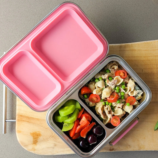 Ecococoon stainless steel leakproof bento box with two compartments and pink rose lid, shown open and filled to highlight its durable metal lunch box design