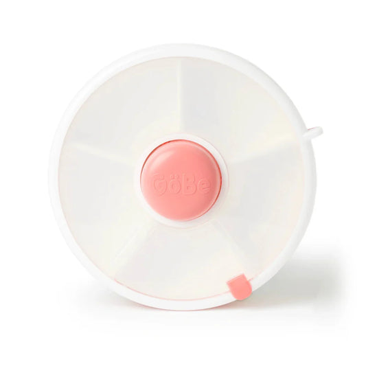 A coral pink GoBe snack spinner with a clear lid and a central button to rotate between different snacks.