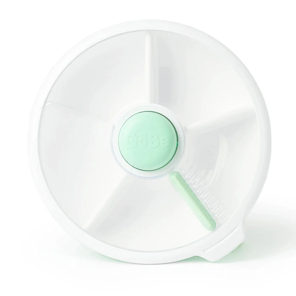 A mint green and white snack spinner designed for children, with compartments to hold multiple snacks.