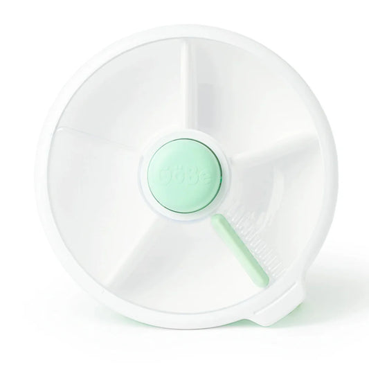 A mint green and white snack spinner designed for children, with compartments to hold multiple snacks.