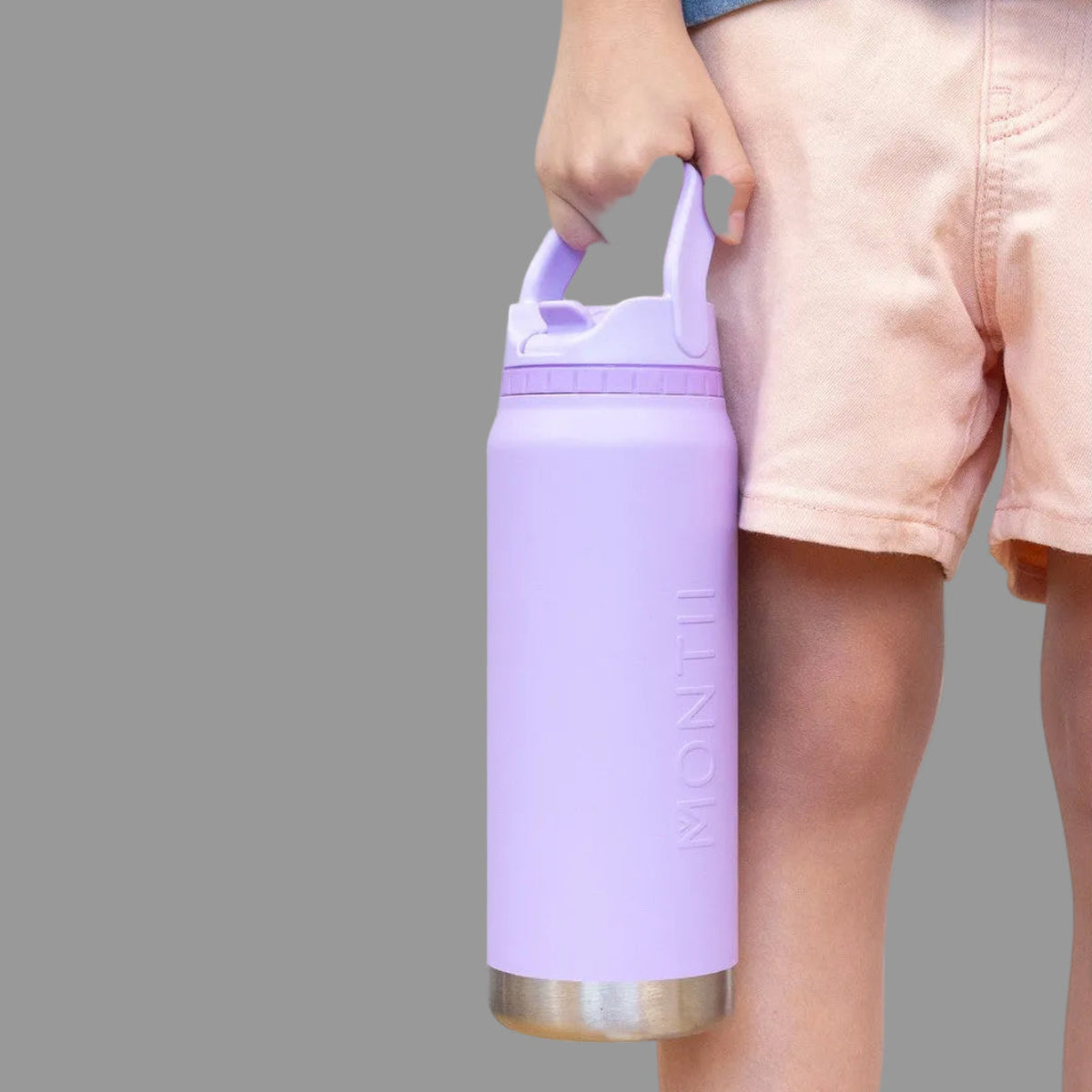 Person holding a purple Lilac water bottle from Montii Co with a white background