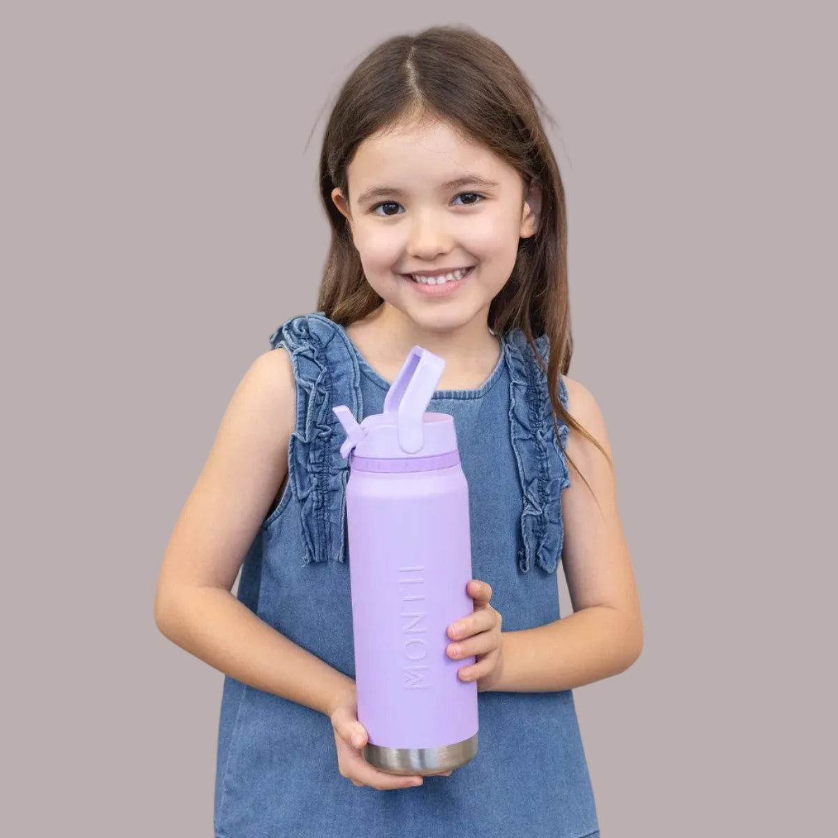 Young girl holding MontiiCo Lilac 750ml Sport Drink Bottle -with a straw lid against a light gray background