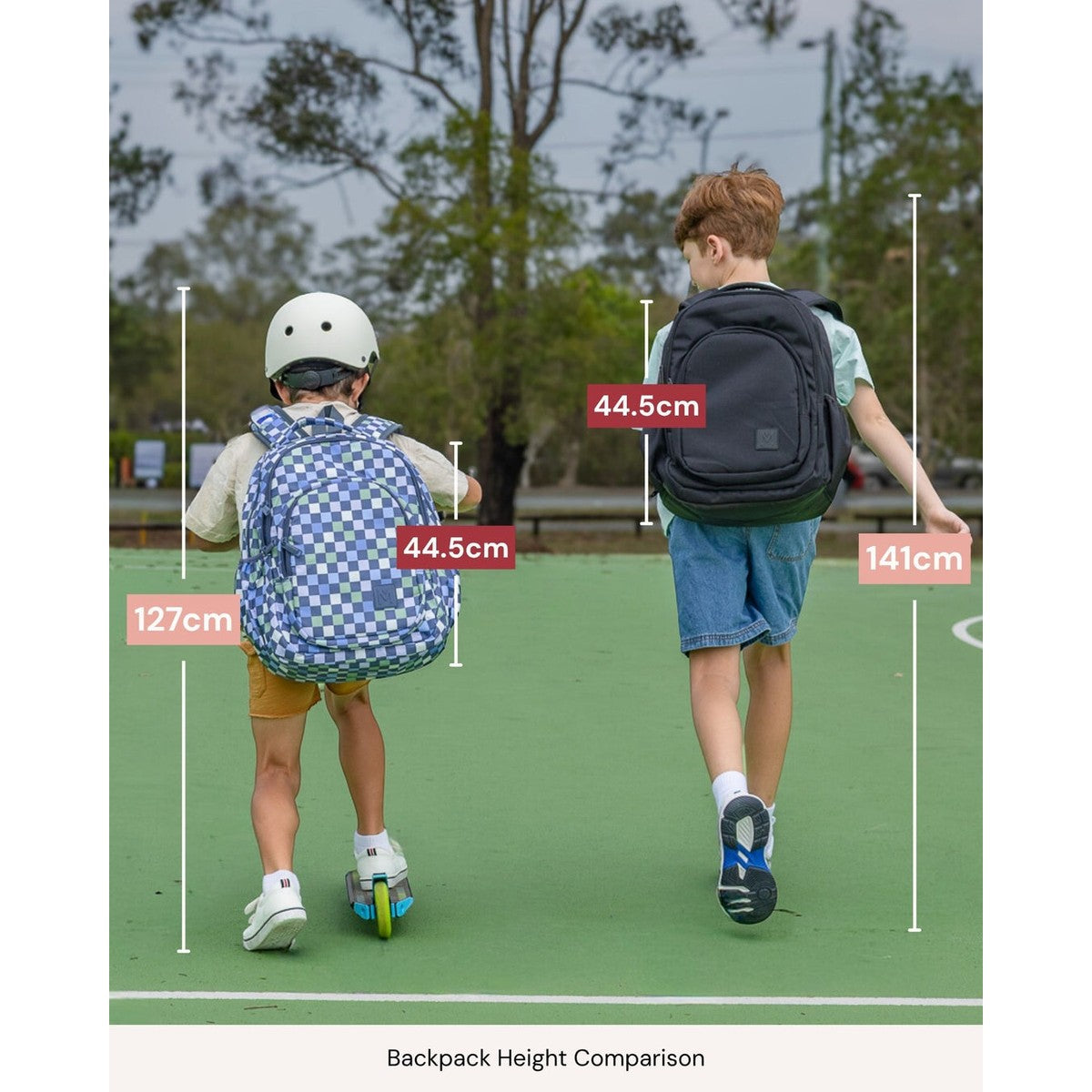Two children with backpacks, showing height comparison measurements outdoors.
