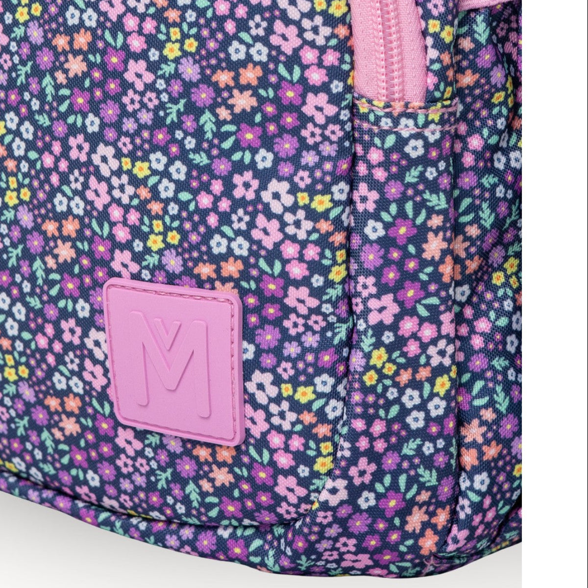 Floral-patterned MontiiCo Mini Backpack - Meadow backpack with a pink logo on a white background