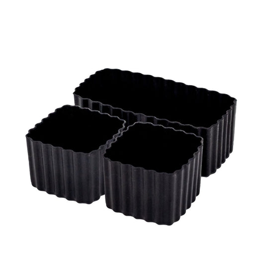 Set of black MontiiCo mixed bento cups with fluted sides, shown in multiple sizes for organising snacks in lunch boxes.