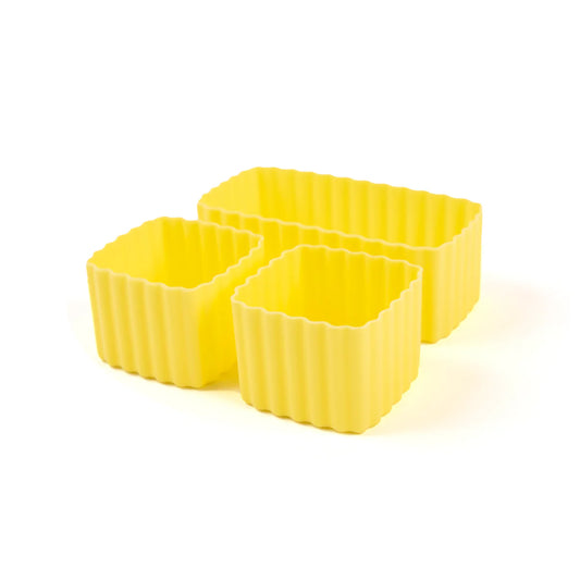 Three yellow bento cups with textured sides on a white backgrounds