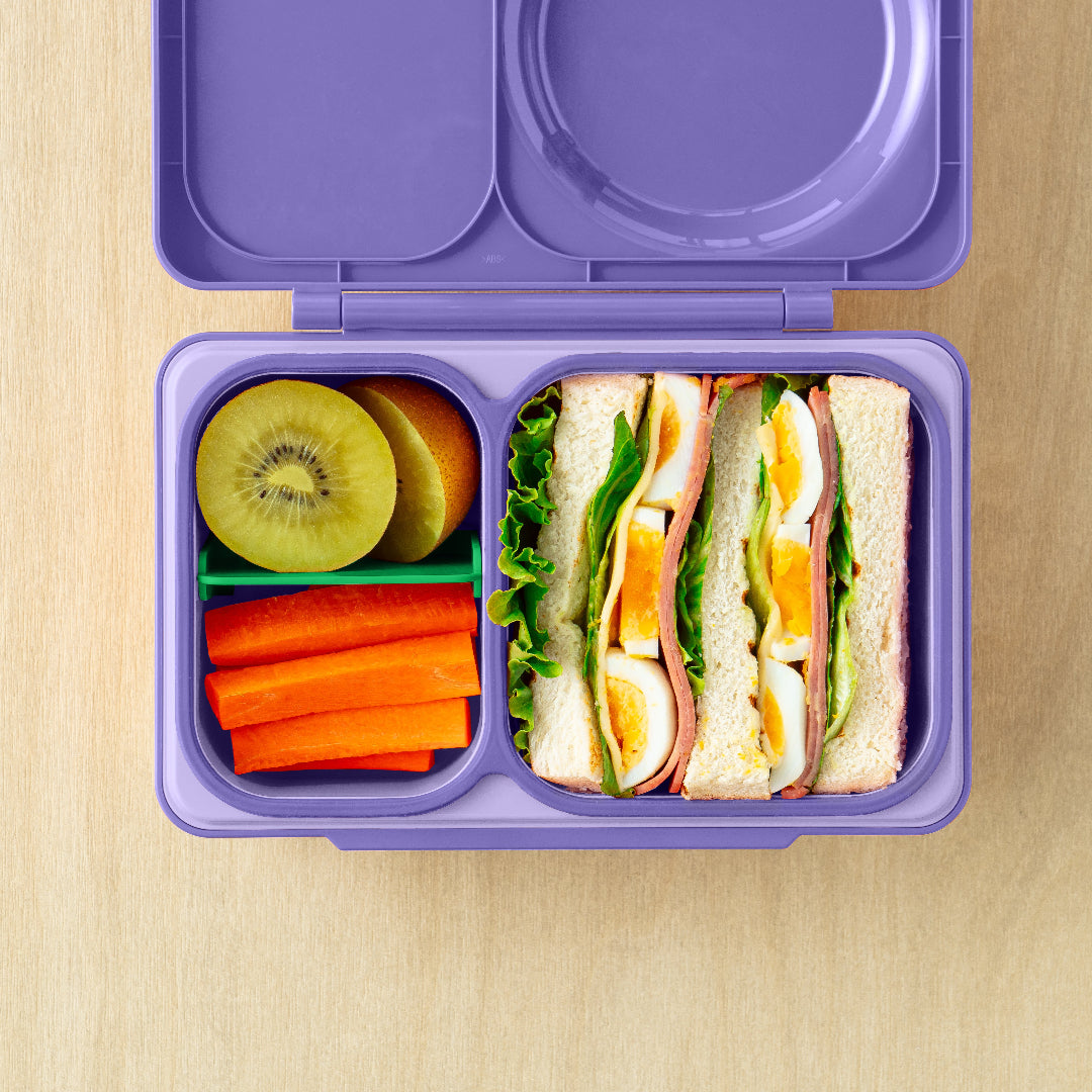 OmieBox Up Galaxy Purple bento lunch box with deep compartments displaying multiple hot and cold meal combinations.