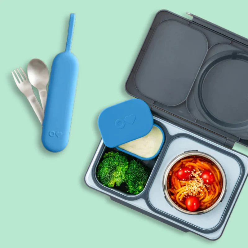 Blue OmieBox Up stainless steel cutlery set displayed beside matching lunch box.