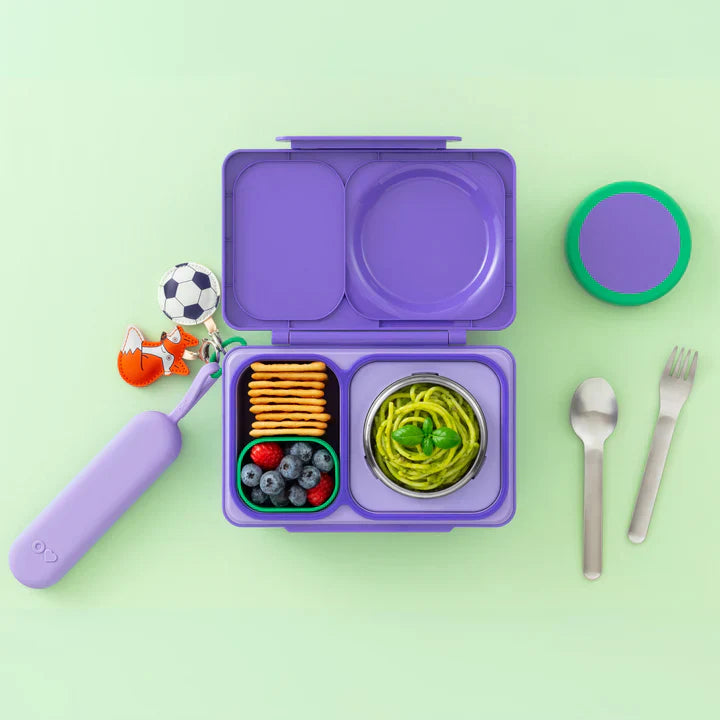 Purple OmieBox Up stainless steel cutlery set displayed beside matching lunch box.