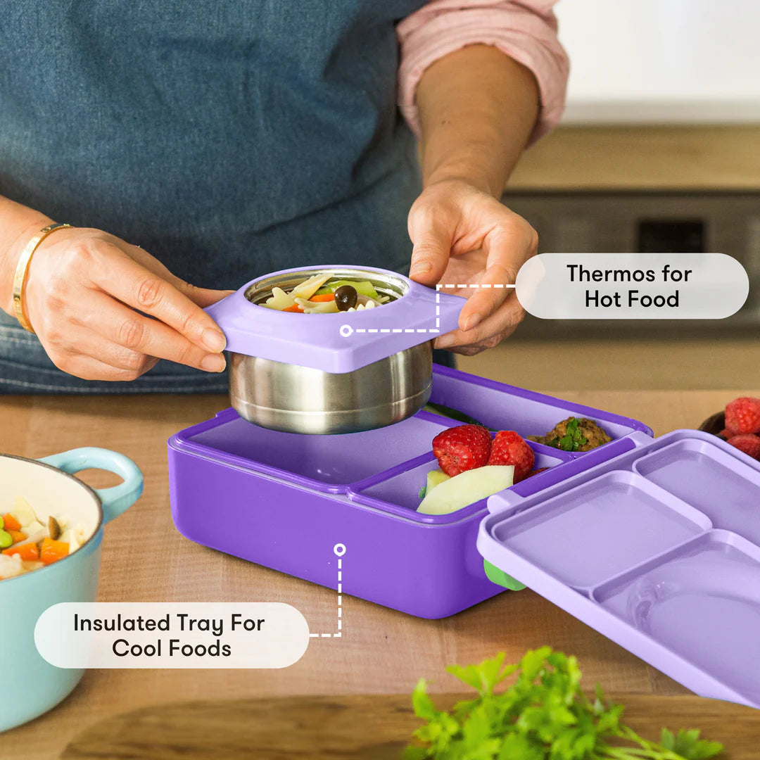 Preparing food in the Lilac Purple OmieBox V2 leakproof bento lunch box with divided compartments.