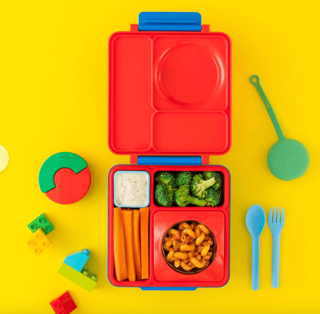 Scooter Red OmieBox V2 leakproof bento box displaying lunch combinations om bright yellow background.