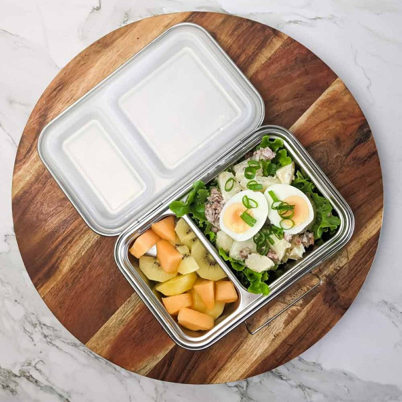 Ecococoon stainless steel leakproof bento box with two compartments and classic design, shown open  on wooden board filled to highlight its durable reusable lunch box design.