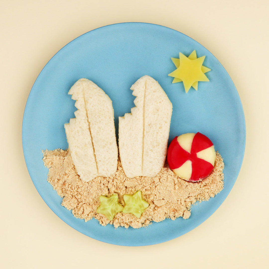 Beach‑themed food plate with shark‑fin sandwiches and ocean‑inspired snacks made using the Lunch Punch Sharks cutters