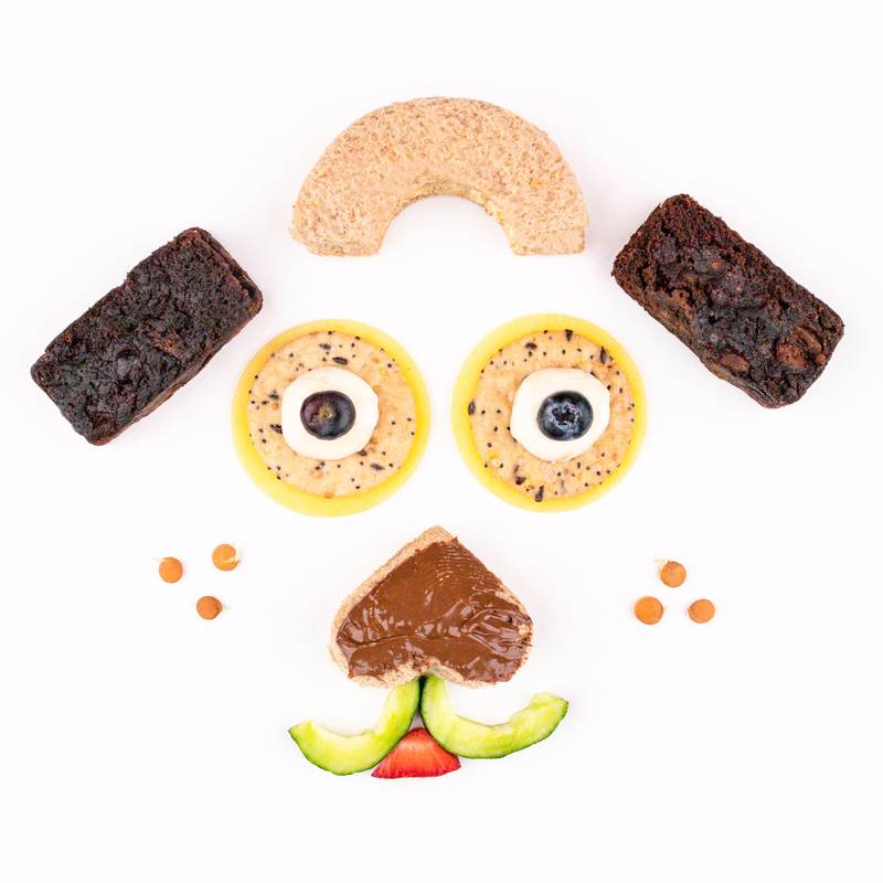 Lunch Punch Mini Bites food art plate featuring a fun face made from shaped snacks and fruit