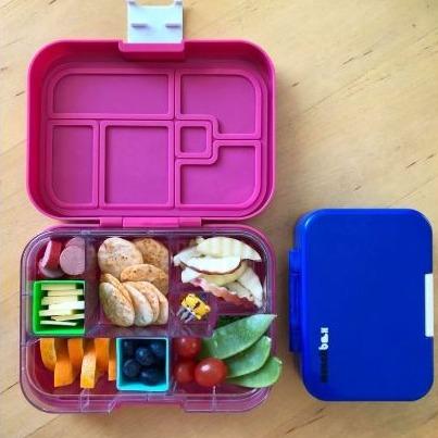 Colourful pastel square silicone bento cups filled with snacks inside a kids’ lunchbox