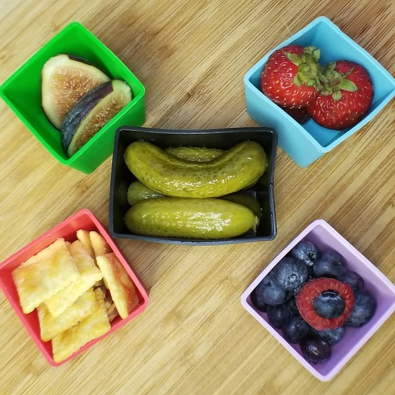 Munch Cups Square Bold displayed on a table with snacks and fruit inside each colourful silicone cup.